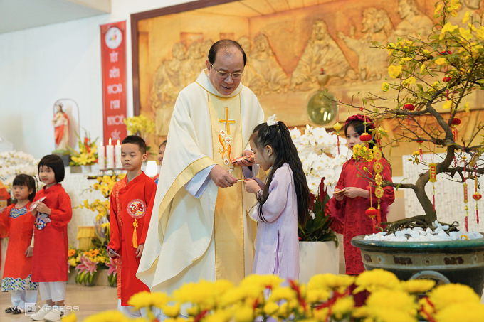 Linh mục Gabriel Nguyễn Ngọc Tuấn, Quản xứ Chính Trạch (Giáo phận Đà Nẵng) lì xì cho các em nhỏ diễn văn nghệ, trong thánh lễ Tân niên. Ảnh: Nguyễn Đông